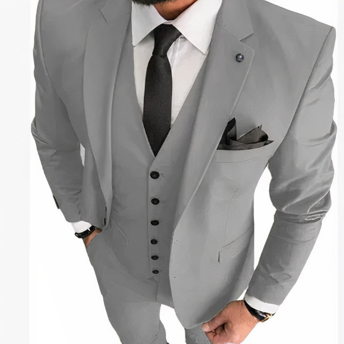Ein Mann in einem schmal geschnittenen formellen Anzug mit klassischem Revers und Hose, der selbstbewusst auf einem Hochzeitsempfang steht.