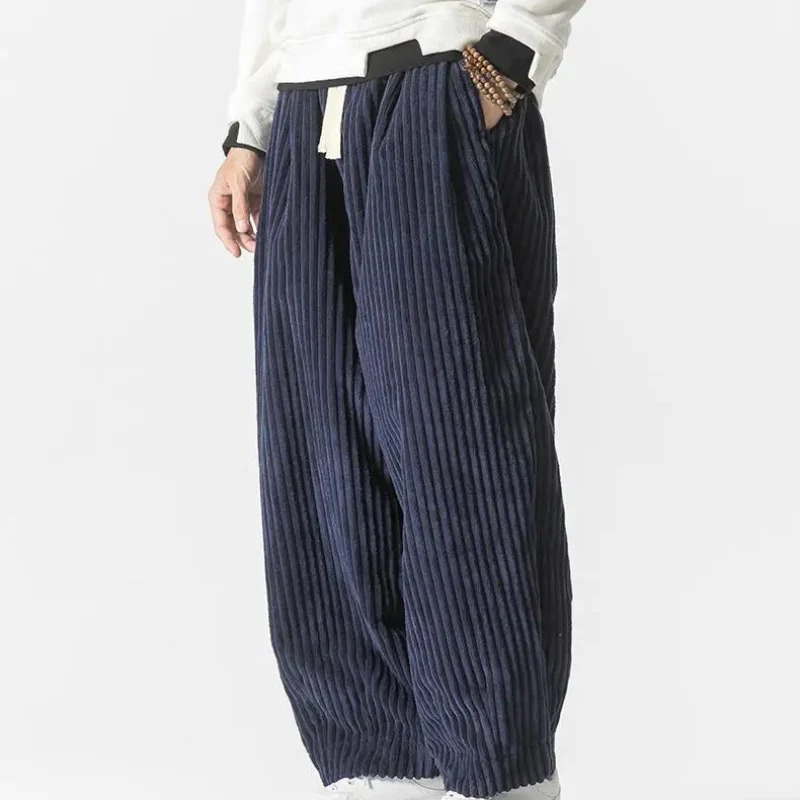 Mann in lässiger Cord-Sommerhose, gestylt mit einfarbigem T-Shirt und Turnschuhen