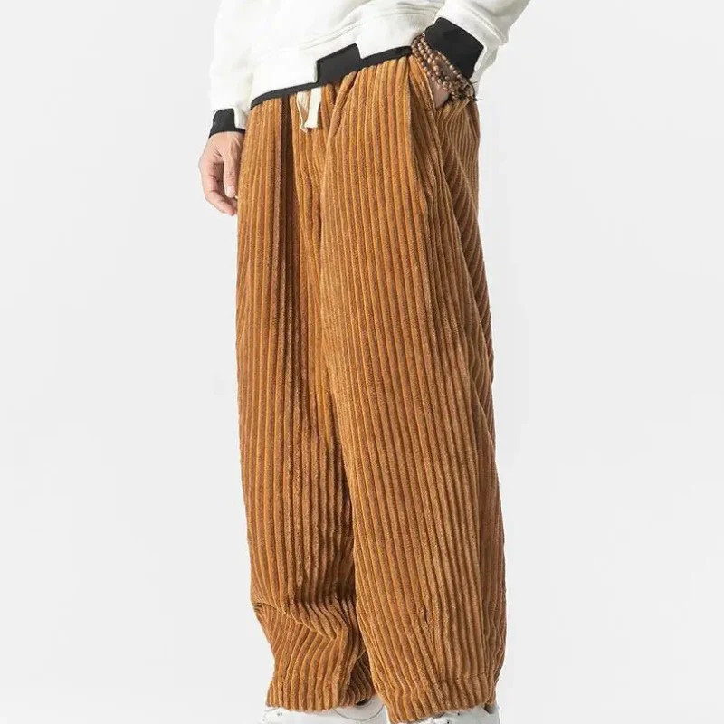 Mann in lässiger Cord-Sommerhose, gestylt mit einfarbigem T-Shirt und Turnschuhen