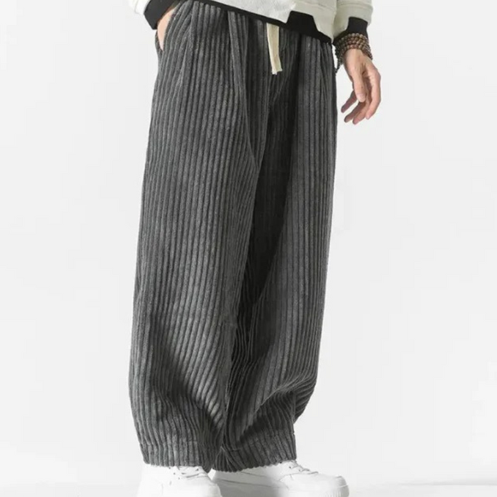 Mann in lässiger Cord-Sommerhose, gestylt mit einfarbigem T-Shirt und Turnschuhen