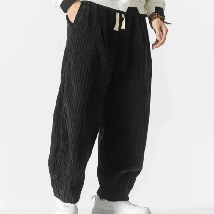 Mann in lässiger Cord-Sommerhose, gestylt mit einfarbigem T-Shirt und Turnschuhen