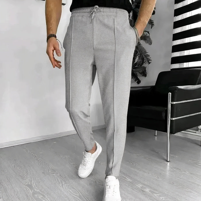 Mann in Slim-Fit-Hose mit Kordelzug, Freizeithemd und Turnschuhen