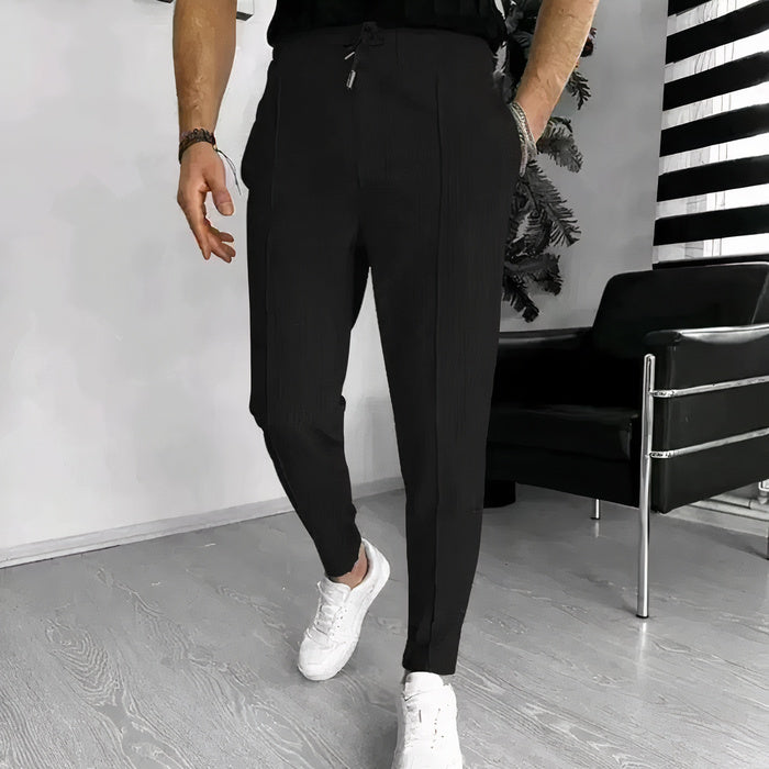 Mann in Slim-Fit-Hose mit Kordelzug, Freizeithemd und Turnschuhen