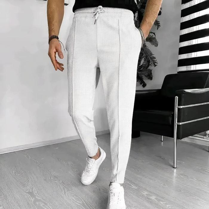 Mann in Slim-Fit-Hose mit Kordelzug, Freizeithemd und Turnschuhen