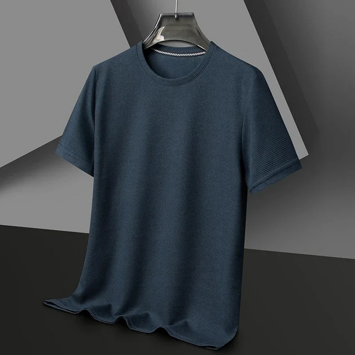 Mann trägt ein strukturiertes kurzärmeliges Sommer-T-Shirt in einer entspannten städtischen Umgebung
