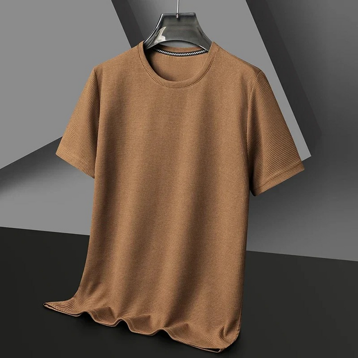 Mann trägt ein strukturiertes kurzärmeliges Sommer-T-Shirt in einer entspannten städtischen Umgebung