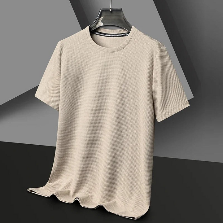 Mann trägt ein strukturiertes kurzärmeliges Sommer-T-Shirt in einer entspannten städtischen Umgebung