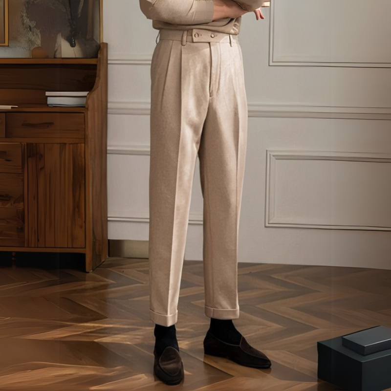 Mann in hochtaillierter Bundfaltenhose, gepaart mit einem formellen Hemd und Slippern