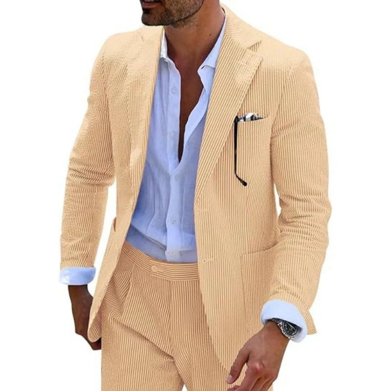 Ein Mann in einem modernen gestreiften Zweireiher mit Revers, der in einer eleganten Hochzeitslocation posiert.