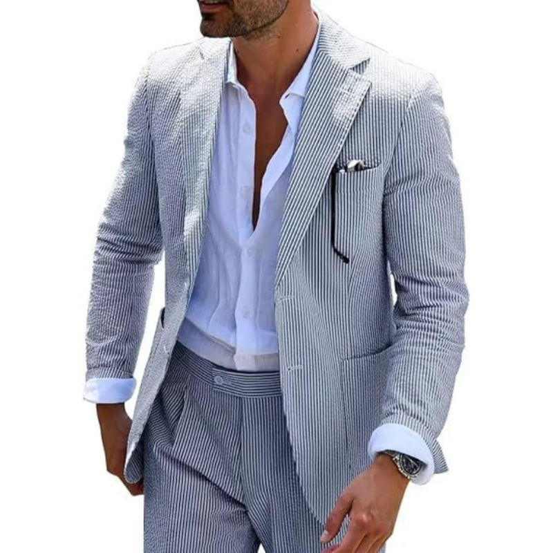 Ein Mann in einem modernen gestreiften Zweireiher mit Revers, der in einer eleganten Hochzeitslocation posiert.