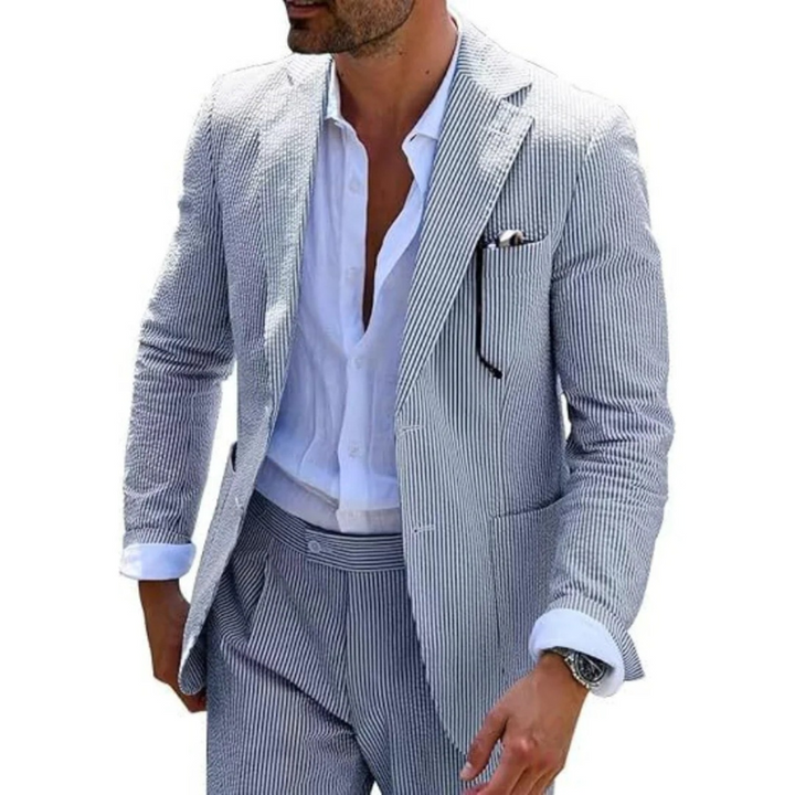 Ein Mann in einem modernen gestreiften Zweireiher mit Revers, der in einer eleganten Hochzeitslocation posiert.