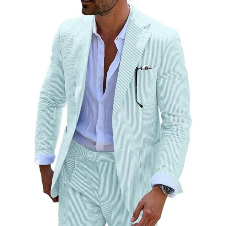 Ein Mann in einem modernen gestreiften Zweireiher mit Revers, der in einer eleganten Hochzeitslocation posiert.