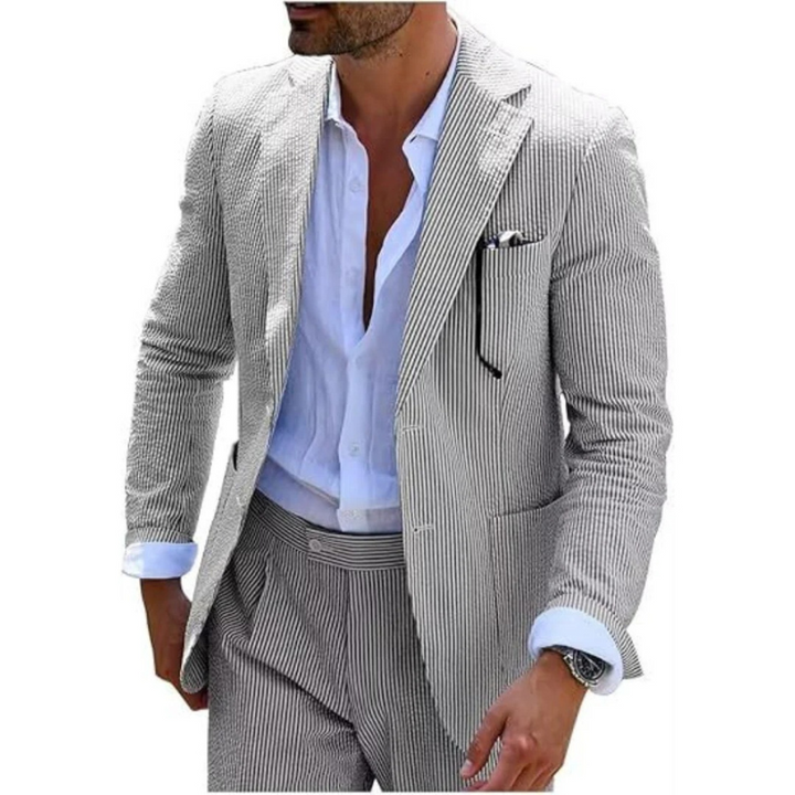 Ein Mann in einem modernen gestreiften Zweireiher mit Revers, der in einer eleganten Hochzeitslocation posiert.