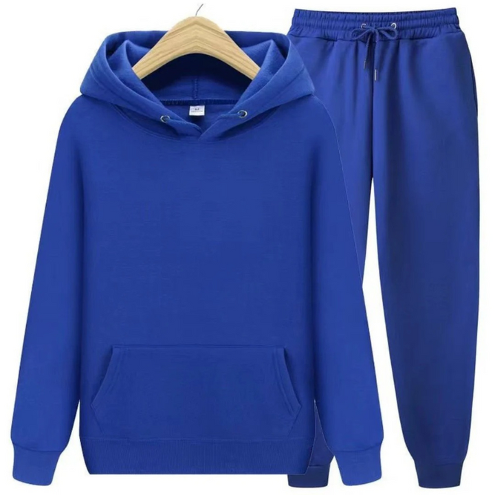 Mann, der einen lässigen zweiteiligen Kapuzenpullover und eine Jogginghose in einer neutralen Farbe trägt, in einer entspannten Umgebung.