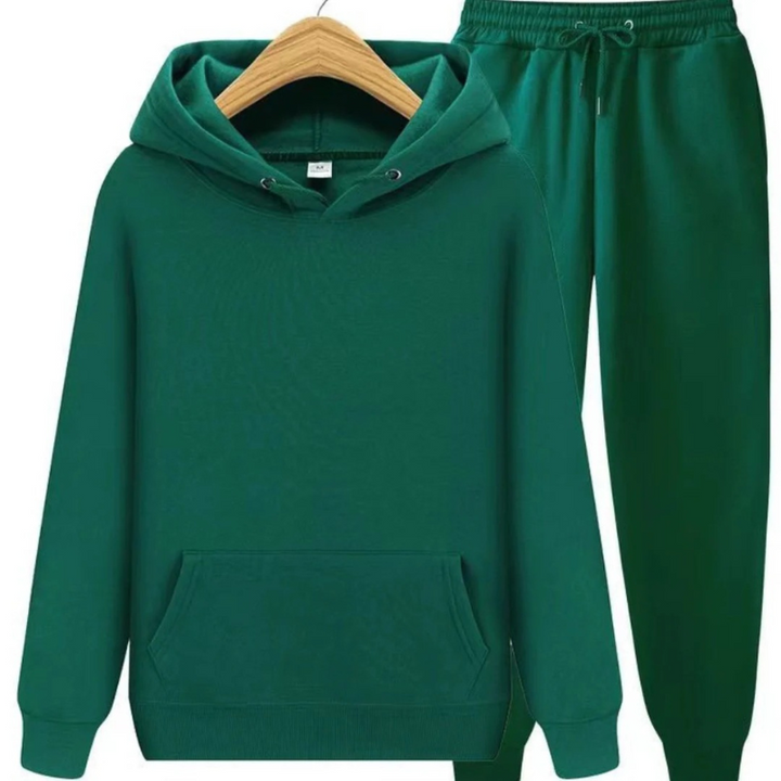 Mann, der einen lässigen zweiteiligen Kapuzenpullover und eine Jogginghose in einer neutralen Farbe trägt, in einer entspannten Umgebung.
