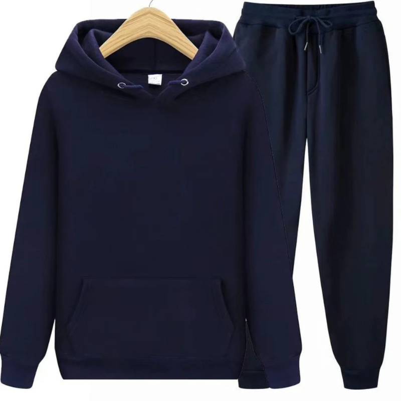 Mann, der einen lässigen zweiteiligen Kapuzenpullover und eine Jogginghose in einer neutralen Farbe trägt, in einer entspannten Umgebung.