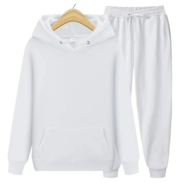 Mann, der einen lässigen zweiteiligen Kapuzenpullover und eine Jogginghose in einer neutralen Farbe trägt, in einer entspannten Umgebung.