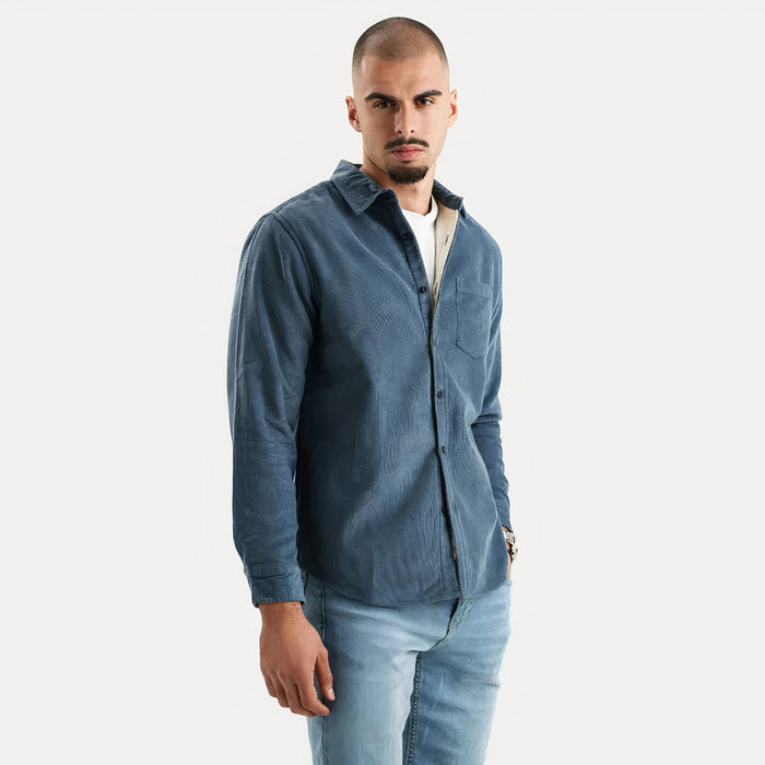 Mann trägt ein warmes langärmeliges Button-Down-Hemd in einer gemütlichen Innenumgebung