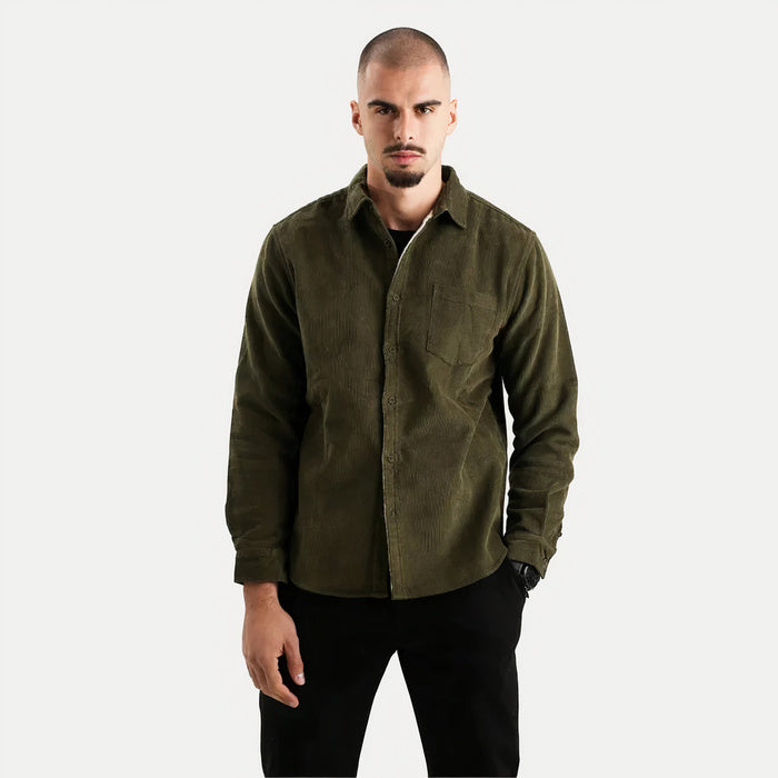 Mann trägt ein warmes langärmeliges Button-Down-Hemd in einer gemütlichen Innenumgebung