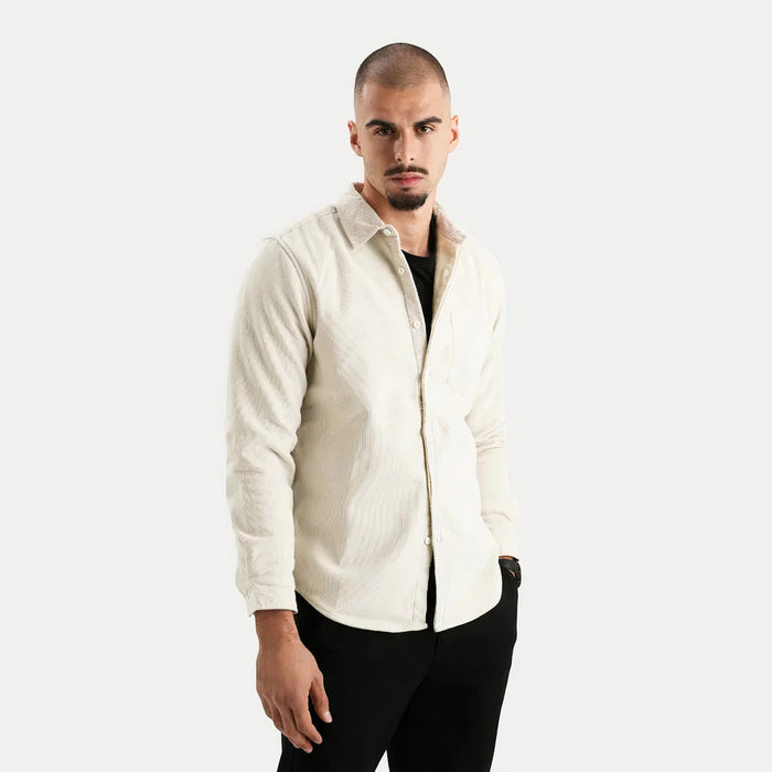 Mann trägt ein warmes langärmeliges Button-Down-Hemd in einer gemütlichen Innenumgebung