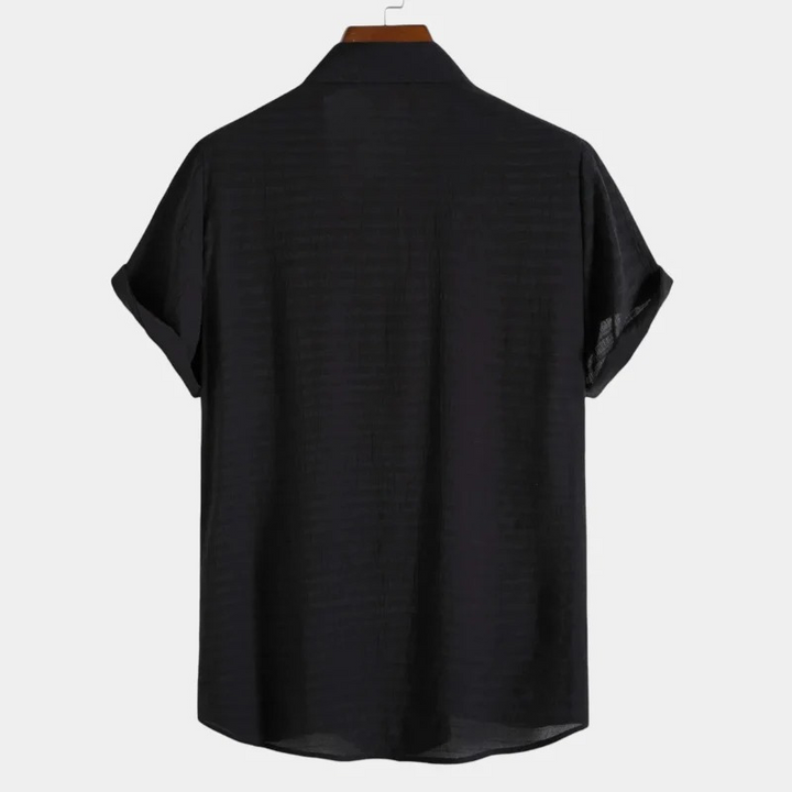 Mann trägt ein leichtes Herrenhemd mit lockerem Schnitt und modernem Design für lässige Outfits an warmen Tagen.