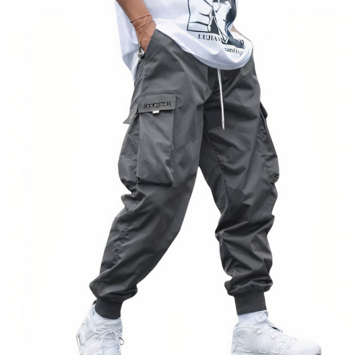 Mann in moderner Cargo-Hose mit weißem T-Shirt und Turnschuhen