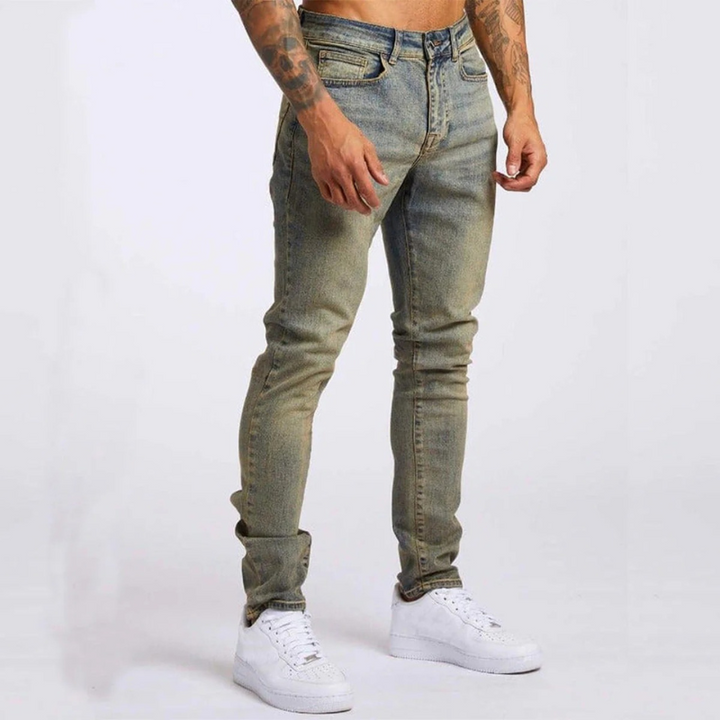Mann trägt Slim-Fit Mid-Rise Stretch-Jeans mit Hemd und Sneakers