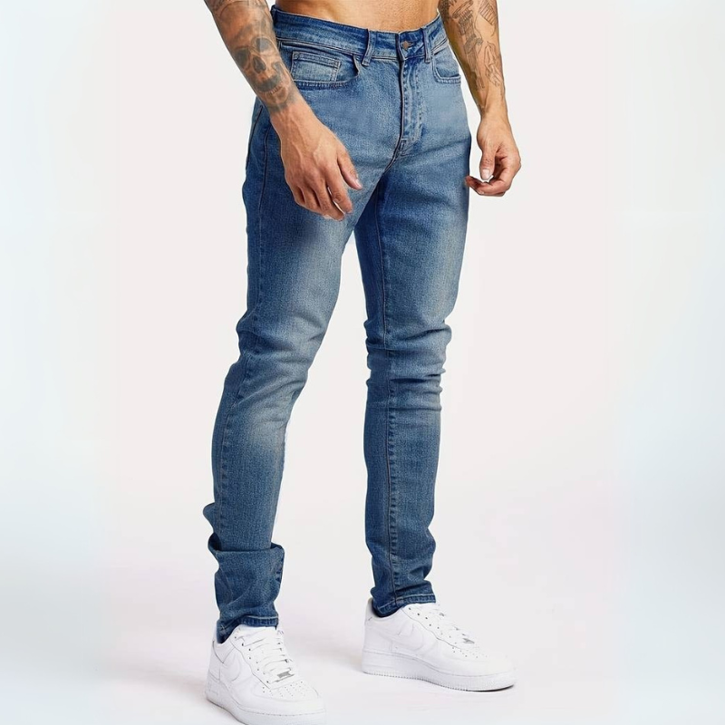 Mann trägt Slim-Fit Mid-Rise Stretch-Jeans mit Hemd und Sneakers