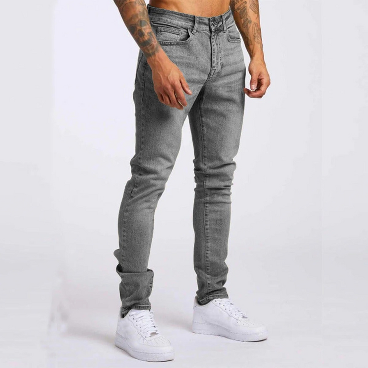 Mann trägt Slim-Fit Mid-Rise Stretch-Jeans mit Hemd und Sneakers