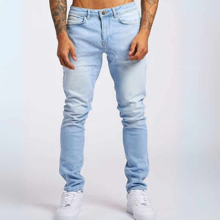 Mann trägt Slim-Fit Mid-Rise Stretch-Jeans mit Hemd und Sneakers