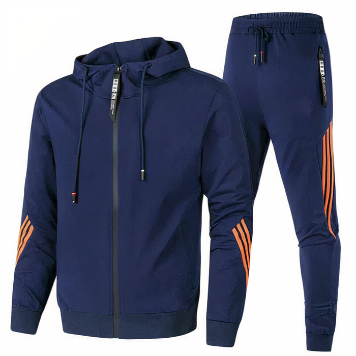 Mann, der einen modernen zweiteiligen blauen Trainingsanzug trägt und in entspannter Haltung im Freien posiert.