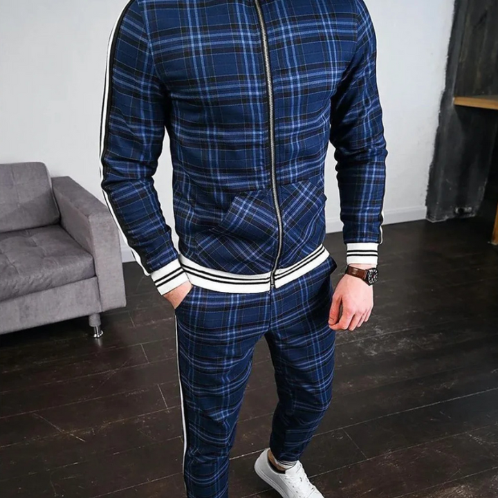 Mann trägt einen karierten Trainingsanzug mit einer Jacke mit Reißverschluss und einer passenden Hose