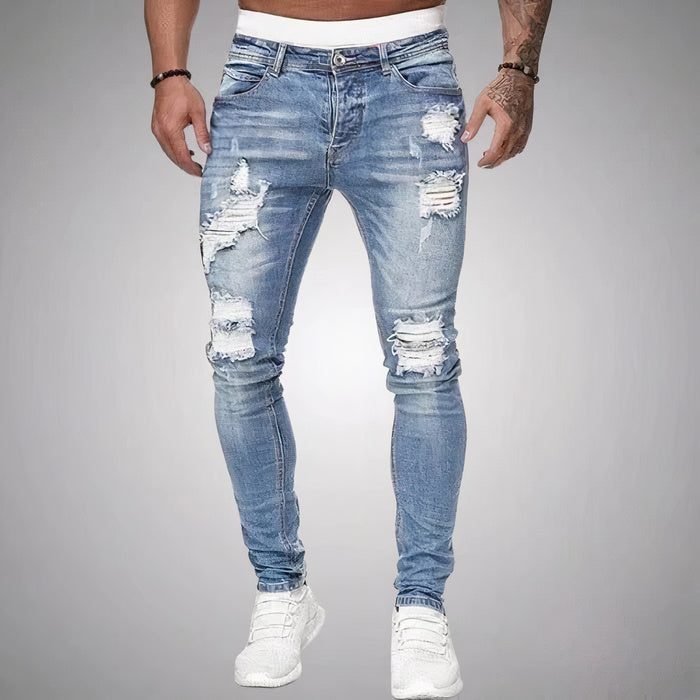 Mann in schmal geschnittener, zerrissener Sommerjeans und lässigem T-Shirt