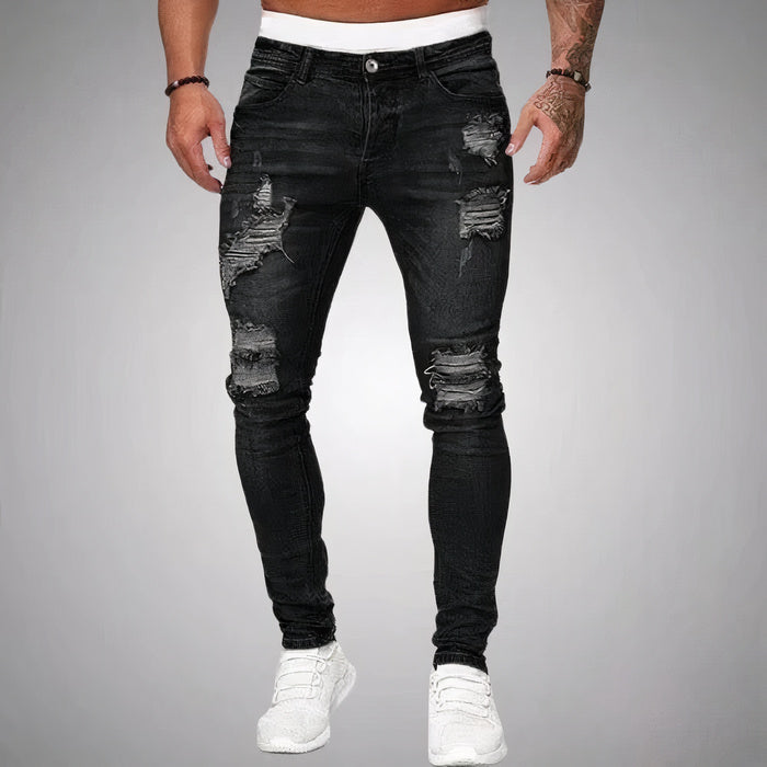 Mann in schmal geschnittener, zerrissener Sommerjeans und lässigem T-Shirt