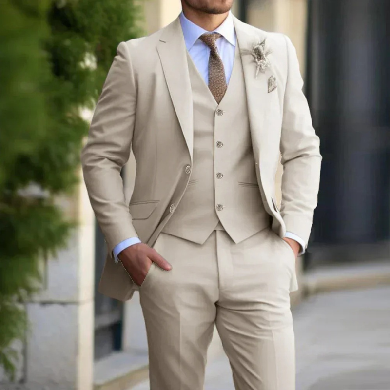 Mann in einem klassischen dreiteiligen Anzug steht selbstbewusst bei einer Hochzeit im Freien