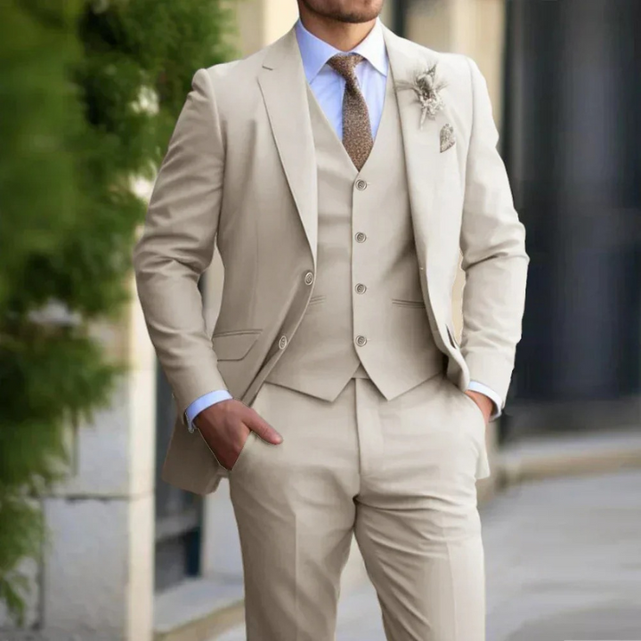 Mann in einem klassischen dreiteiligen Anzug steht selbstbewusst bei einer Hochzeit im Freien