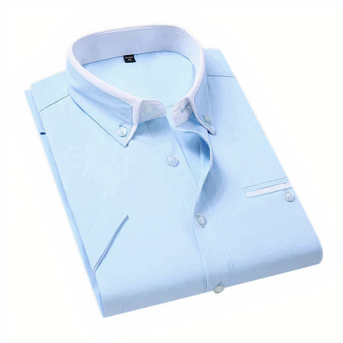 Mann in klassischem weißen Business-Button-down-Hemd steht selbstbewusst da
