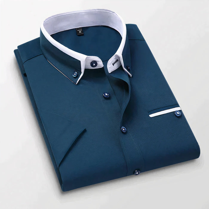 Mann in klassischem weißen Business-Button-down-Hemd steht selbstbewusst da
