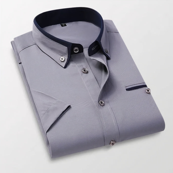 Mann in klassischem weißen Business-Button-down-Hemd steht selbstbewusst da
