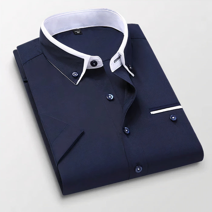 Mann in klassischem weißen Business-Button-down-Hemd steht selbstbewusst da
