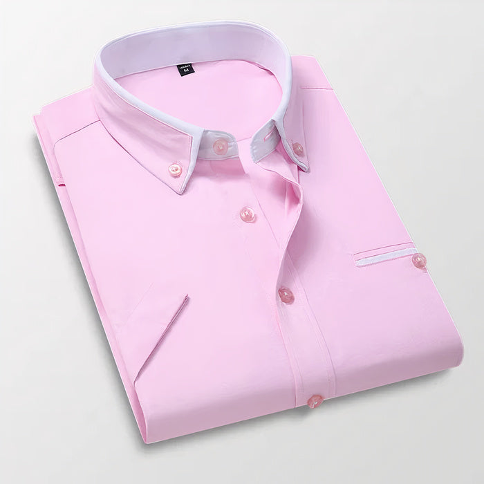 Mann in klassischem weißen Business-Button-down-Hemd steht selbstbewusst da
