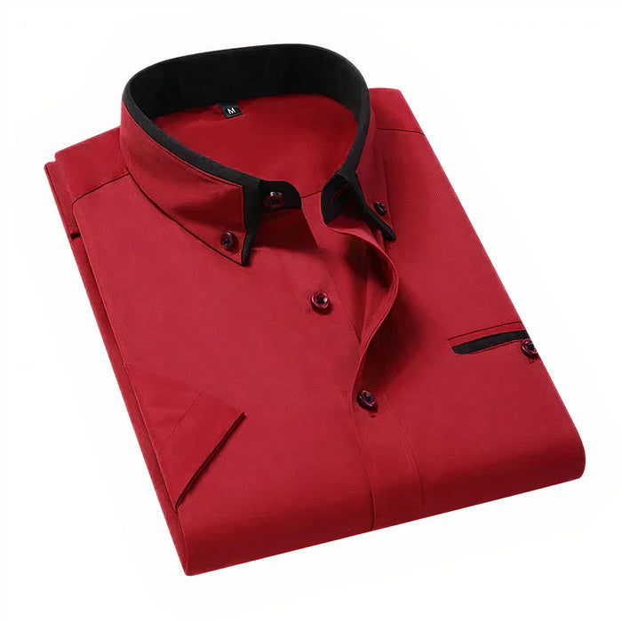 Mann in klassischem weißen Business-Button-down-Hemd steht selbstbewusst da
