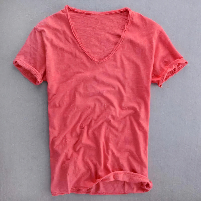 Mann trägt ein lässiges Sommer-T-Shirt mit V-Ausschnitt und Jeans in einer lässigen Umgebung im Freien
