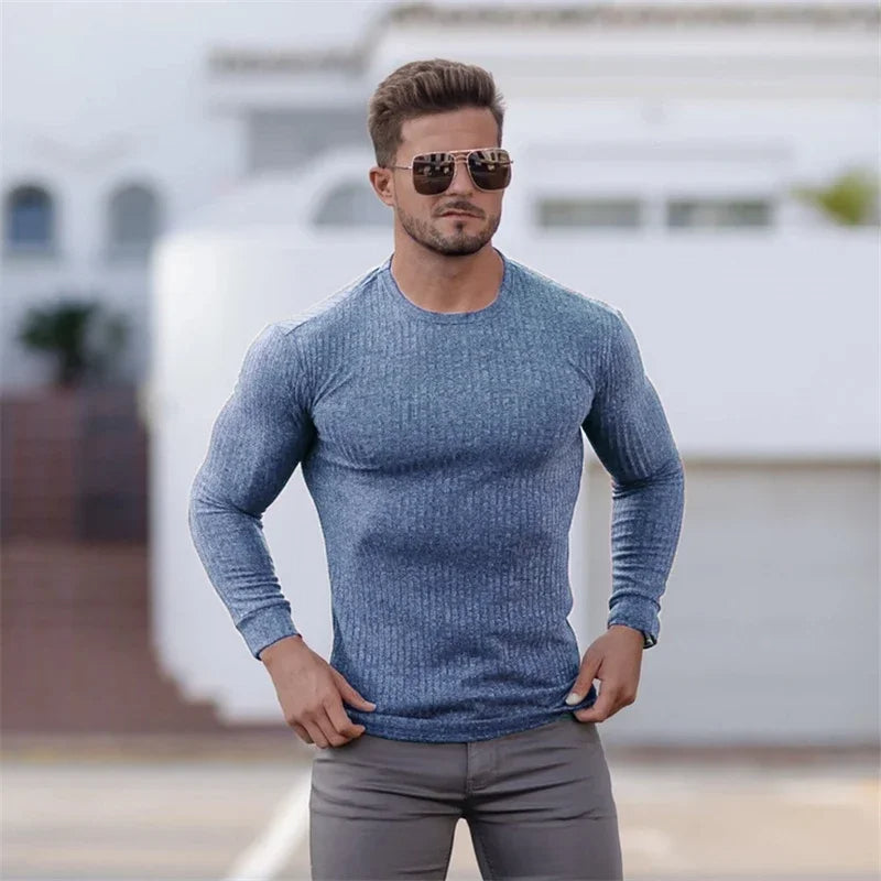 Ein Mann trägt einen modischen Pullover in Muskelausführung