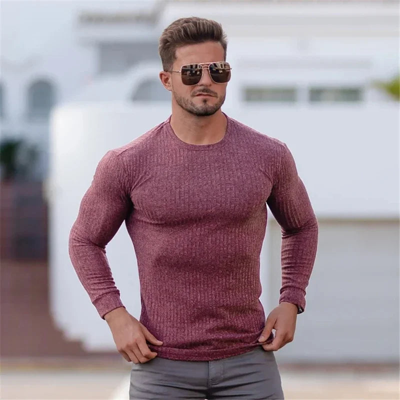 Ein Mann trägt einen modischen Pullover in Muskelausführung