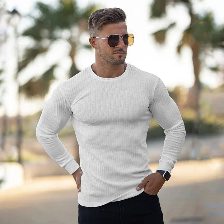 Ein Mann trägt einen modischen Pullover in Muskelausführung