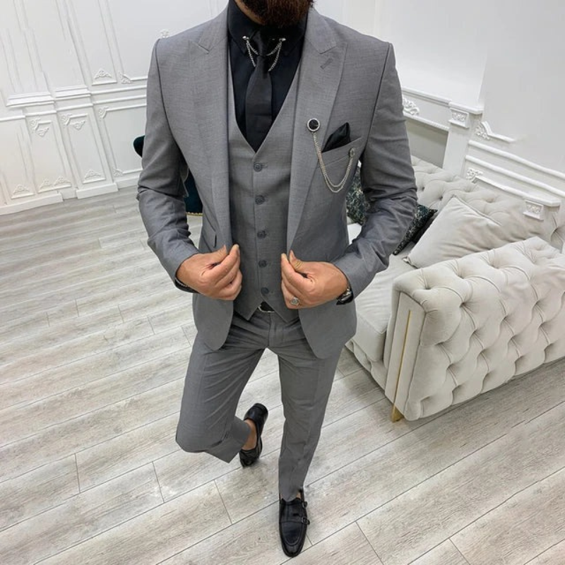 Ein Mann trägt einen dreiteiligen Premium-Anzug mit Blazer, Weste und Hose bei einer formellen Hochzeit.