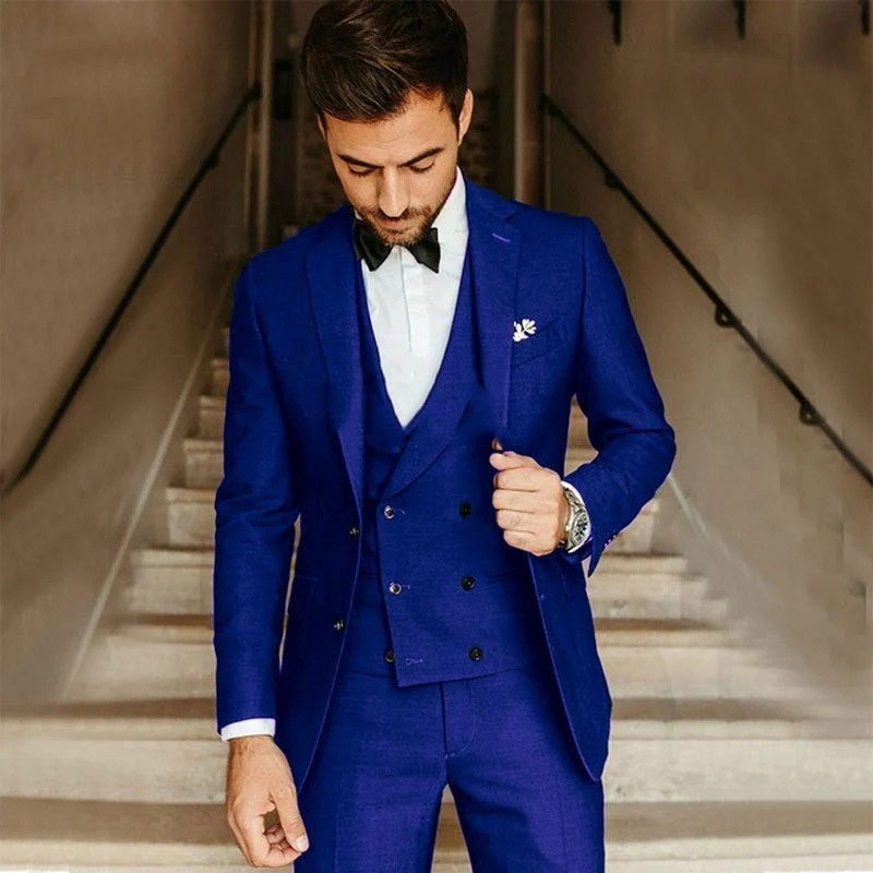 Ein Mann trägt einen klassischen dreiteiligen Anzug mit Blazer, Weste und Hose in einer formellen Umgebung.