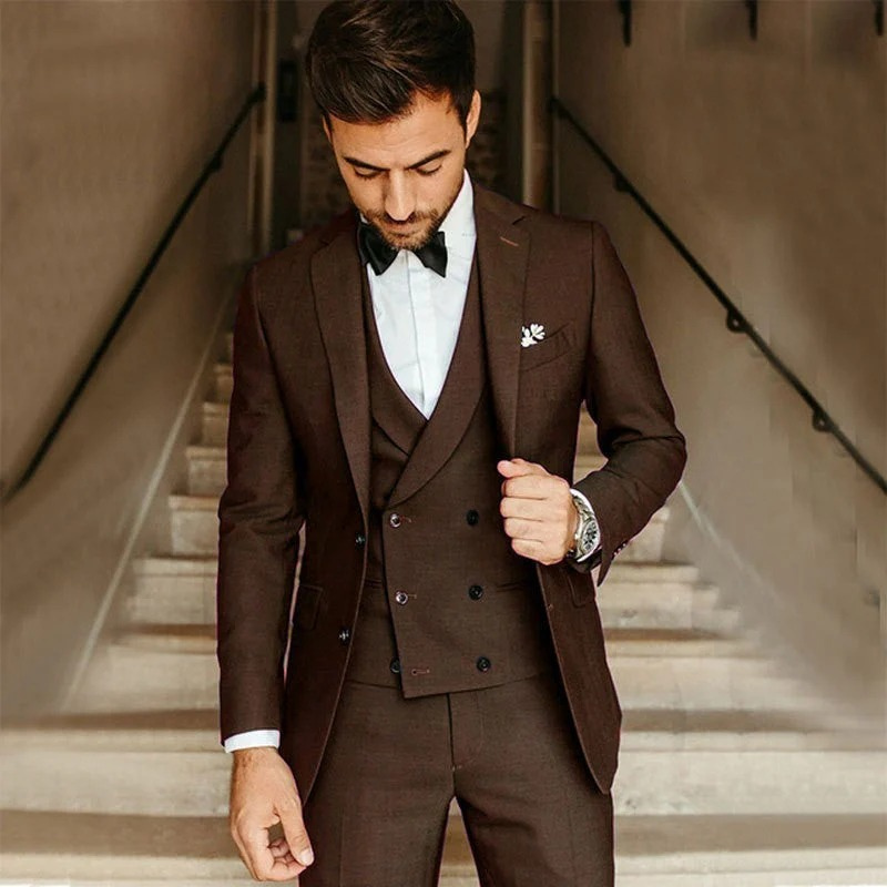 Ein Mann trägt einen klassischen dreiteiligen Anzug mit Blazer, Weste und Hose in einer formellen Umgebung.
