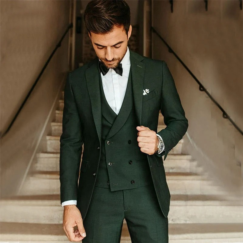 Ein Mann trägt einen klassischen dreiteiligen Anzug mit Blazer, Weste und Hose in einer formellen Umgebung.